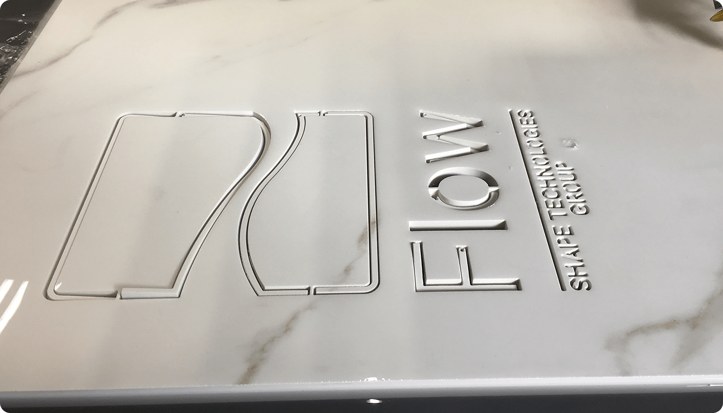 Das mit einem Wasserstrahl aus Marmor geschnittene Flow-Logo