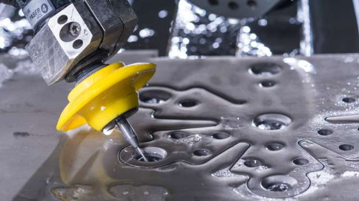 Nahaufnahme des Wasserstrahlschneidkopfes, der ein kompliziertes Muster in Metall schneidet